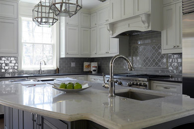 Eat-in kitchen photo in Chicago with white cabinets, gray backsplash, stainless steel appliances and an island
