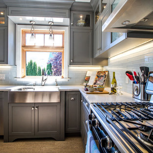 Imagen de cocina en L, contemporánea, pequeña, cerrada, con fregadero sobremueble, armarios estilo shaker, puertas de armario grises, encimera de cuarzo compacto, salpicadero blanco, salpicadero de azulejos de vidrio, electrodomésticos de acero inoxidable, suelo de corcho y una isla