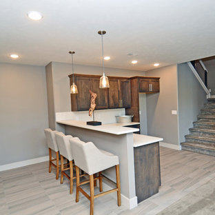 Photo of a mid-sized traditional l-shaped open plan kitchen in Other with an undermount sink, shaker cabinets, dark wood cabinets, quartz benchtops, white splashback, porcelain splashback, stainless steel appliances, vinyl floors and a peninsula.
