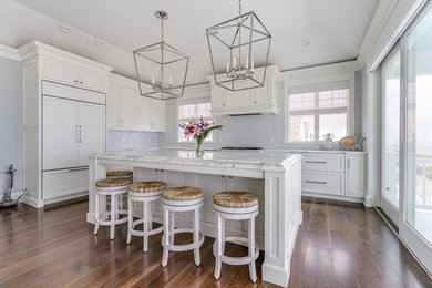 Eat-in kitchen - mid-sized transitional l-shaped dark wood floor and brown floor eat-in kitchen idea in Philadelphia with an undermount sink, recessed-panel cabinets, white cabinets, marble countertops, white backsplash, paneled appliances and an island