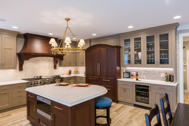 Eat-in kitchen - large traditional u-shaped porcelain tile and brown floor eat-in kitchen idea in Cincinnati with an undermount sink, recessed-panel cabinets, beige cabinets, quartz countertops, beige backsplash, ceramic backsplash, paneled appliances, an island and white countertops