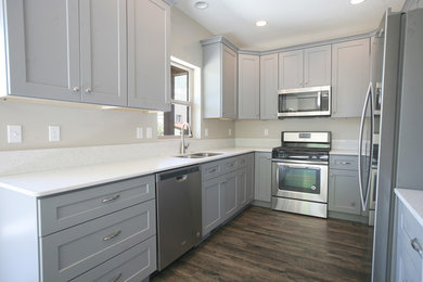 Kitchen photo in Other with an undermount sink, gray cabinets, quartz countertops, stainless steel appliances and white countertops