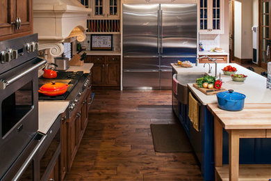 Inspiration for a large craftsman l-shaped dark wood floor kitchen remodel in San Francisco with a farmhouse sink, recessed-panel cabinets, dark wood cabinets, quartz countertops, white backsplash, subway tile backsplash, stainless steel appliances and an island