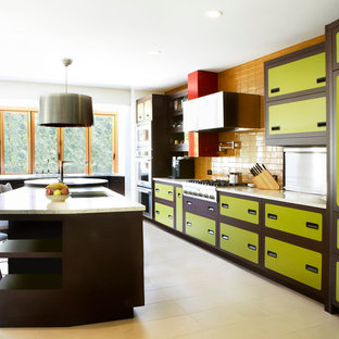 This is an example of an eclectic galley kitchen in San Francisco with green cabinets, yellow splashback and stainless steel appliances.
