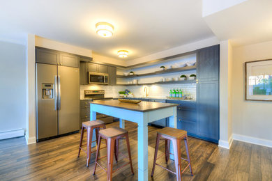Open concept kitchen - mid-sized transitional l-shaped dark wood floor open concept kitchen idea in Minneapolis with an undermount sink, open cabinets, gray cabinets, granite countertops, white backsplash, subway tile backsplash, colored appliances and an island