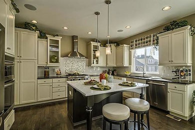 Kitchen - kitchen idea in Denver with white cabinets, white backsplash, stainless steel appliances and an island