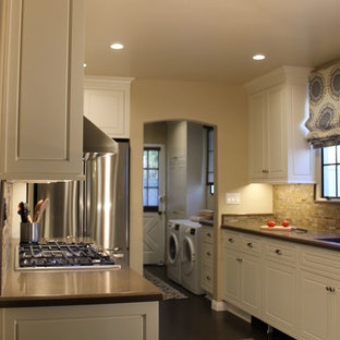 Photo of a large transitional galley separate kitchen in Los Angeles with a double-bowl sink, beaded inset cabinets, white cabinets, quartz benchtops, beige splashback, slate splashback, stainless steel appliances, cork floors, no island and brown floor.