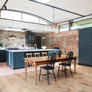 Ejemplo de cocina comedor en U, de estilo de casa de campo, extra grande, con encimera de granito, electrodomésticos negros, suelo de baldosas de terracota, una isla, suelo multicolor, armarios estilo shaker, puertas de armario azules, fregadero integrado y encimeras blancas