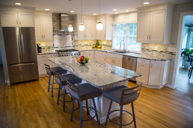 Mid-sized trendy l-shaped medium tone wood floor eat-in kitchen photo in New York with a single-bowl sink, shaker cabinets, white cabinets, granite countertops, green backsplash, porcelain backsplash, stainless steel appliances and an island