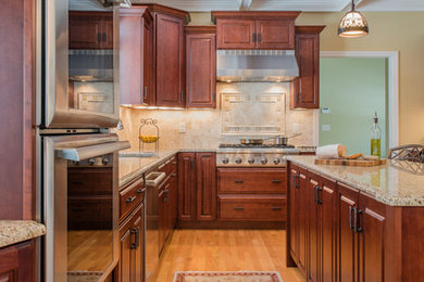 Kitchen - large transitional light wood floor kitchen idea in Boston with an undermount sink, medium tone wood cabinets, granite countertops, stone tile backsplash, stainless steel appliances and an island