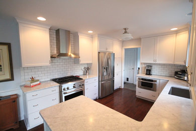 Elegant u-shaped eat-in kitchen photo in New York with an undermount sink, shaker cabinets, white cabinets, marble countertops, white backsplash, subway tile backsplash and stainless steel appliances