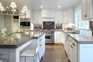 Eat-in kitchen - large contemporary u-shaped eat-in kitchen idea in Las Vegas with a farmhouse sink, shaker cabinets, white cabinets, multicolored backsplash, stainless steel appliances and an island