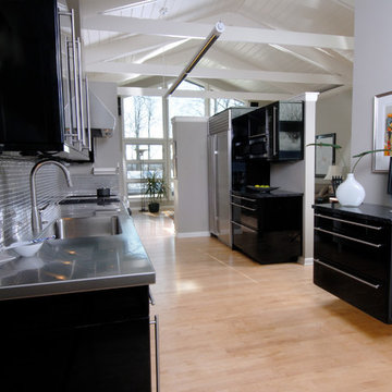 A contemporary kitchen with vaulted ceilings and high gloss black cabinets