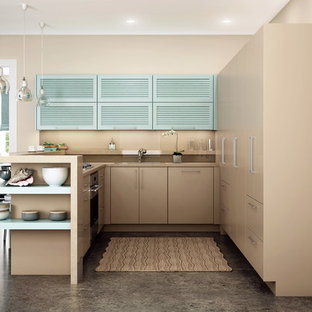 Small modern galley eat-in kitchen in San Francisco with with island, an undermount sink, louvered cabinets, brown splashback, panelled appliances, blue cabinets, solid surface benchtops, ceramic splashback, laminate floors and grey floor.