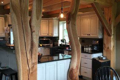 Exempel på ett litet lantligt kök med öppen planlösning, med en rustik diskho, luckor med upphöjd panel, vita skåp, granitbänkskiva, rostfria vitvaror, mellanmörkt trägolv, en halv köksö och brunt golv