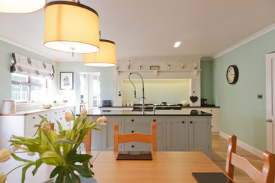 This is an example of a large contemporary kitchen/diner in Other with a submerged sink, shaker cabinets, granite worktops, light hardwood flooring and an island.