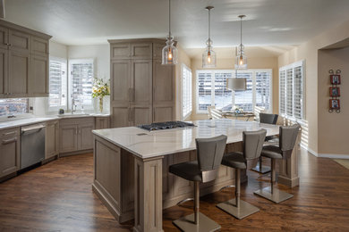 Large transitional single-wall medium tone wood floor and brown floor eat-in kitchen photo in Denver with an undermount sink, shaker cabinets, gray cabinets, quartz countertops, white backsplash, ceramic backsplash, paneled appliances, an island and white countertops