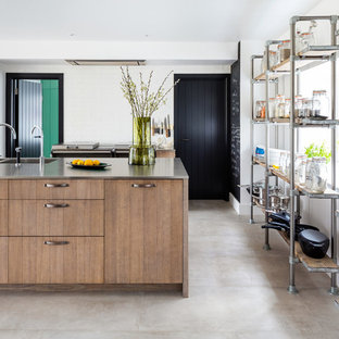 Medium sized industrial kitchen in Gloucestershire with flat-panel cabinets, an island, light wood cabinets, stainless steel worktops, grey floors and grey worktops.
