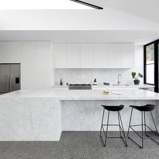 Photo of a large contemporary kitchen in Melbourne with an undermount sink, white cabinets, marble benchtops, white splashback, marble splashback, stainless steel appliances, concrete floors, with island, grey floor, white benchtop and flat-panel cabinets.