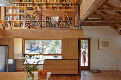 Foto de cocina campestre con puertas de armario de madera oscura, armarios con paneles lisos, electrodomésticos de acero inoxidable y suelo de madera en tonos medios