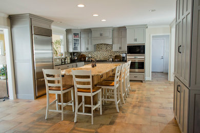 Eat-in kitchen - large transitional u-shaped porcelain tile eat-in kitchen idea in Philadelphia with mosaic tile backsplash, stainless steel appliances, a farmhouse sink, shaker cabinets, gray cabinets, granite countertops, multicolored backsplash and an island
