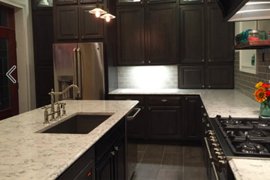 Example of a mid-sized urban kitchen design in Cincinnati with raised-panel cabinets, granite countertops and an island