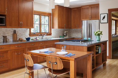 Example of a mid-sized arts and crafts l-shaped bamboo floor and beige floor eat-in kitchen design in San Francisco with shaker cabinets, medium tone wood cabinets, stainless steel appliances, an island, quartz countertops, beige backsplash and ceramic backsplash
