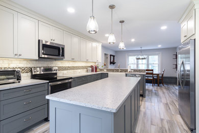 Example of a large transitional eat-in kitchen design in Philadelphia with a farmhouse sink, stainless steel appliances and an island