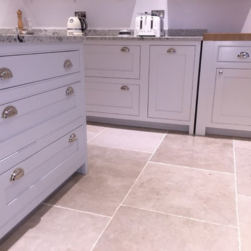 A light, bright, white hand painted kitchen with open shelving and large island