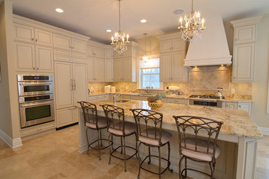 Example of a large tuscan galley travertine floor kitchen design in Detroit with a single-bowl sink, raised-panel cabinets, granite countertops, beige backsplash, stone tile backsplash, stainless steel appliances and an island