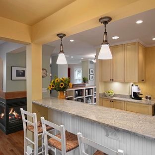 Design ideas for a mid-sized traditional l-shaped open plan kitchen in Detroit with an undermount sink, shaker cabinets, beige cabinets, granite benchtops, stainless steel appliances, dark hardwood floors, no island, blue floor and beige benchtop.
