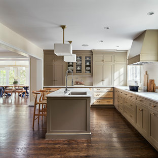 Large transitional l-shaped eat-in kitchen in Philadelphia with an undermount sink, marble benchtops, white splashback, porcelain splashback, stainless steel appliances, dark hardwood floors, with island, white benchtop, shaker cabinets, brown cabinets and brown floor.