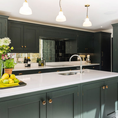 Inspiration for a large timeless l-shaped limestone floor and beige floor eat-in kitchen remodel in London with shaker cabinets, green cabinets, quartzite countertops, metallic backsplash, paneled appliances, an island, white countertops, an undermount sink and mirror backsplash