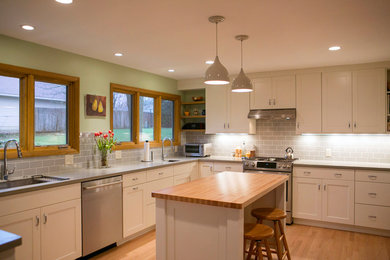 Moderne Küche in U-Form mit Schrankfronten im Shaker-Stil, weißen Schränken, Betonarbeitsplatte, hellem Holzboden und Kücheninsel in Sonstige