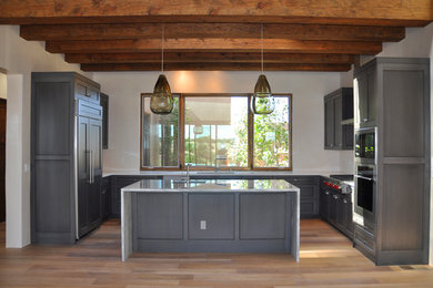 Mid-sized minimalist u-shaped light wood floor eat-in kitchen photo in Albuquerque with an undermount sink, shaker cabinets, gray cabinets, marble countertops, white backsplash, stainless steel appliances and an island