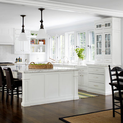 Inspiration for a mid-sized timeless l-shaped dark wood floor eat-in kitchen remodel in New York with white cabinets, white backsplash, subway tile backsplash, stainless steel appliances, an island and beaded inset cabinets
