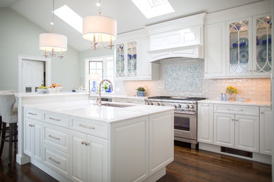 Example of a large beach style galley dark wood floor and brown floor kitchen pantry design in Bridgeport with an undermount sink, raised-panel cabinets, white cabinets, granite countertops, gray backsplash, subway tile backsplash, stainless steel appliances, an island and white countertops