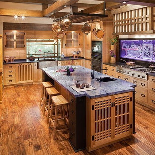 Large asian enclosed kitchen pictures - Example of a large u-shaped medium tone wood floor enclosed kitchen design in Los Angeles with medium tone wood cabinets, granite countertops, an island, an undermount sink and black appliances