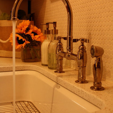 A penny-round backsplash and bridge faucet maintain the feel of the 100yo home.