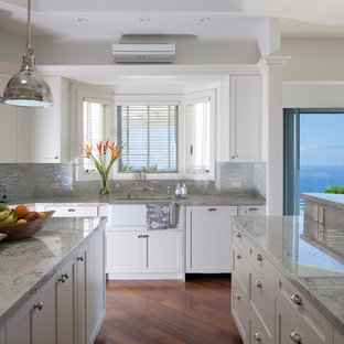 Idee per una cucina tropicale con lavello stile country, ante in stile shaker, ante bianche, elettrodomestici in acciaio inossidabile e top in granito
