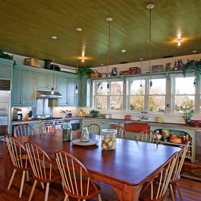 Example of a mountain style eat-in kitchen design in Nashville with stainless steel appliances and a farmhouse sink