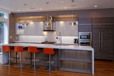 Eat-in kitchen - modern galley eat-in kitchen idea in San Francisco with flat-panel cabinets, gray cabinets, quartz countertops, white backsplash, porcelain backsplash, stainless steel appliances and an undermount sink