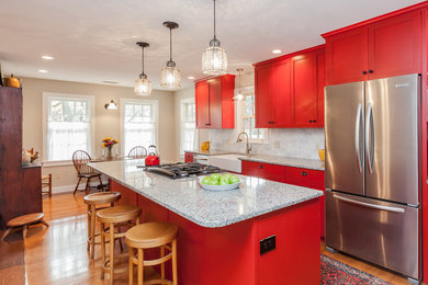 Inspiration for a mid-sized timeless galley light wood floor eat-in kitchen remodel in Boston with a farmhouse sink, shaker cabinets, red cabinets, granite countertops, gray backsplash, subway tile backsplash, stainless steel appliances and an island