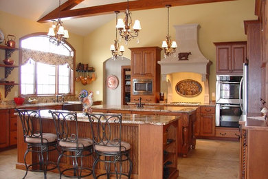Photo of a large farmhouse u-shaped open plan kitchen in Cedar Rapids with a submerged sink, raised-panel cabinets, medium wood cabinets, granite worktops, stainless steel appliances, ceramic flooring, multiple islands and beige floors.