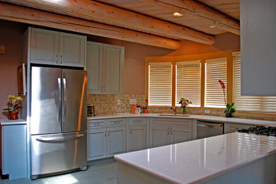 アルバカーキにある中くらいなサンタフェスタイルのおしゃれなキッチン (アンダーカウンターシンク、インセット扉のキャビネット、青いキャビネット、珪岩カウンター、マルチカラーのキッチンパネル、セラミックタイルのキッチンパネル、シルバーの調理設備、スレートの床、アイランドなし) の写真