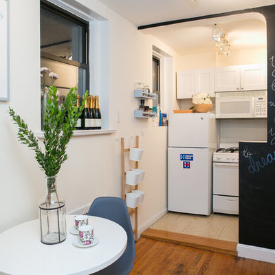 Small cottage chic single-wall medium tone wood floor eat-in kitchen photo in New York with white cabinets