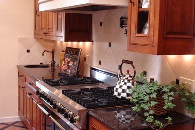 Large u-shaped terra-cotta tile kitchen pantry photo in San Francisco with a farmhouse sink, beaded inset cabinets, medium tone wood cabinets, granite countertops, white backsplash, stone tile backsplash, stainless steel appliances and an island