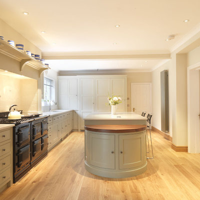 Eat-in kitchen - large traditional u-shaped light wood floor eat-in kitchen idea in Hampshire with shaker cabinets, beige cabinets, quartz countertops, beige backsplash, ceramic backsplash, black appliances and an island