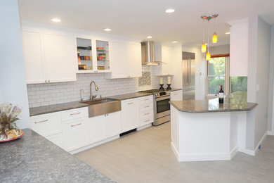 Example of a mid-sized transitional galley porcelain tile and gray floor eat-in kitchen design in New York with a farmhouse sink, shaker cabinets, white cabinets, quartzite countertops, white backsplash, ceramic backsplash, stainless steel appliances and a peninsula