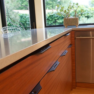 This is an example of a mid-sized midcentury u-shaped kitchen in Denver with a double-bowl sink, flat-panel cabinets, medium wood cabinets, quartz benchtops, yellow splashback, stainless steel appliances and light hardwood floors.